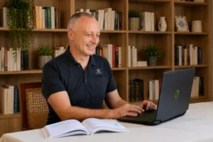 Arnaud Brun en consultation de micronutrition devant son ordinateur, avec un livre ouvert sur le bureau.